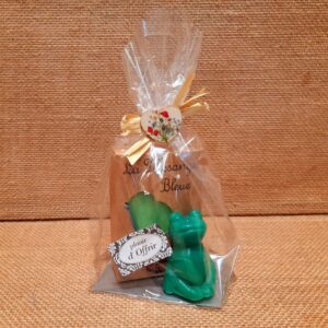 Sachet cadeau contenant un savon parfumé et un savon en forme de grenouille de couleur vert, sur un fond en jute
